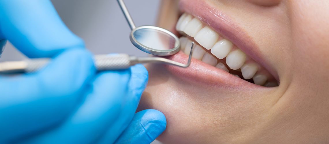 Girl with beautiful white teeth on reception at the doctor dentist.