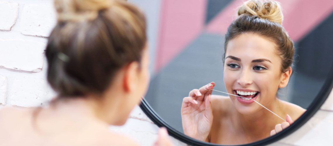 Picture of young woman brushing teeth in bathroom