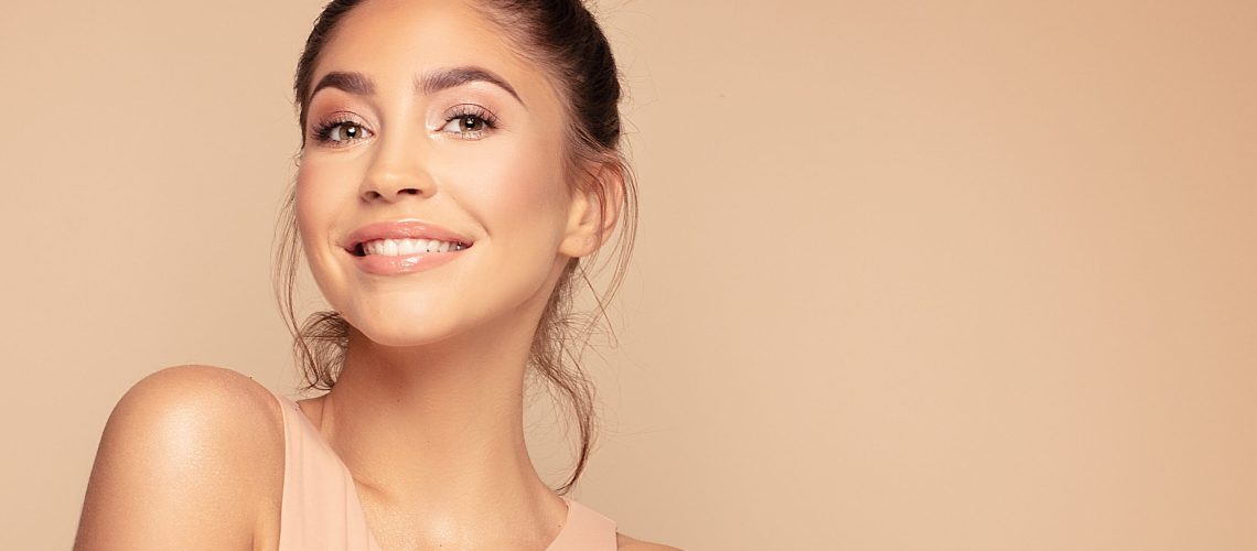 Beauty face of young beautiful smile woman with a fresh healthy skin. Skin care concept. Beauty treatment. A lot of copy space.